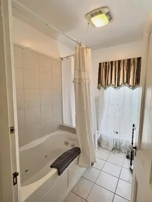 a white bathroom with a tub and a window at Historic Sion Bass Guest House in Fort Wayne