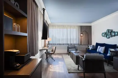 a living room with a blue couch and chairs at Renaissance Columbus Westerville-Polaris Hotel in Westerville