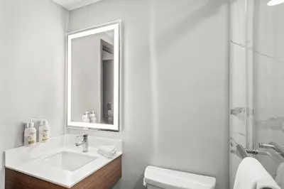 a white bathroom with a sink and a mirror at Microtel Inn by Wyndham Lexington in Lexington