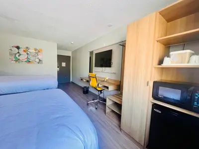 a hotel room with a bed and a desk and a tv at Microtel Inn by Wyndham Lexington in Lexington