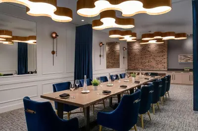 a conference room with a long table and blue chairs at DoubleTree by Hilton Canton Downtown in Canton
