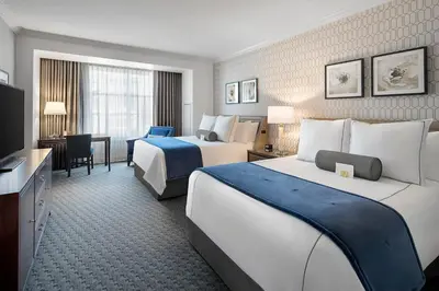 a hotel room with two beds and a television at The Hancock Hotel in Findlay