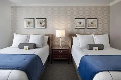 a hotel room with two beds with blue sheets at The Hancock Hotel in Findlay