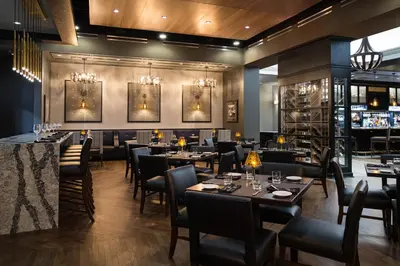a restaurant with tables and chairs and a bar at The Hancock Hotel in Findlay