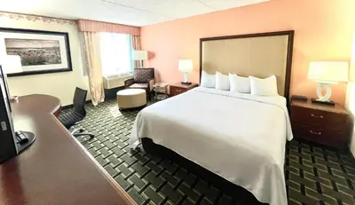 a hotel room with a large bed and a desk at Fairbridge Hotel Cleveland East in Wickliffe