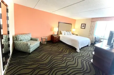 a hotel room with a bed and a chair at Fairbridge Hotel Cleveland East in Wickliffe