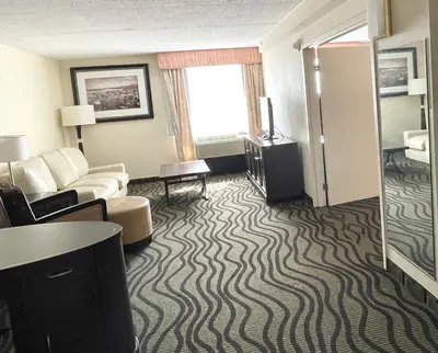 a hotel room with a couch and a living room at Fairbridge Hotel Cleveland East in Wickliffe