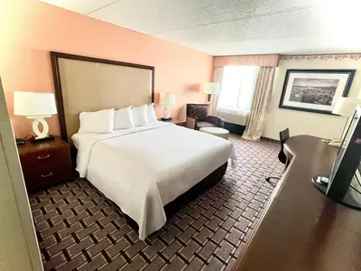 a hotel room with a large bed and a desk at Fairbridge Hotel Cleveland East in Wickliffe