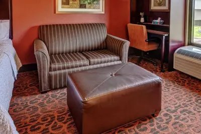 a room with a couch and a chair and a ottoman at Hampton Inn Ashland in Ashland