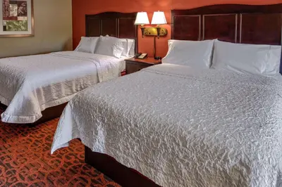 two beds in a hotel room with white sheets at Hampton Inn Ashland in Ashland