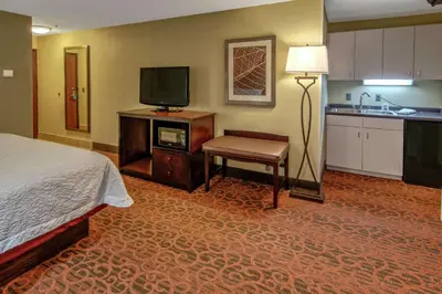 a hotel room with a bed and a flat screen tv at Hampton Inn Ashland in Ashland