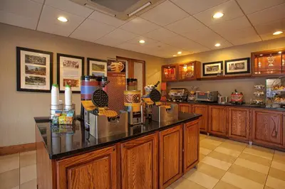 a kitchen with wooden cabinets and a counter top at Hampton Inn Wheeling in Wheeling