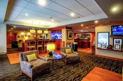 a lobby with chairs and a table and a bar at Hampton Inn Wheeling in Wheeling