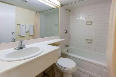 a bathroom with a sink and a toilet and a tub at Travelodge by Wyndham Cleveland Airport in Brook Park