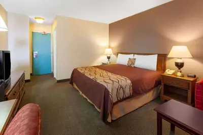 a hotel room with a bed and a flat screen tv at Travelodge by Wyndham Cleveland Airport in Brook Park