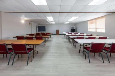 an empty classroom with tables and chairs and a chalkboard at Travelodge by Wyndham Cleveland Airport in Brook Park