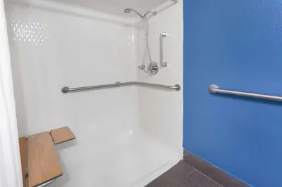 a bathroom with a shower with a blue wall at Baymont by Wyndham Milan in Milan