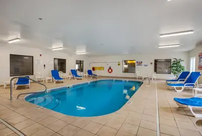 a pool in a waiting room with blue chairs at Baymont by Wyndham Milan in Milan