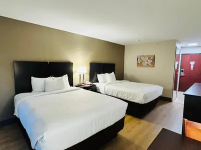 a hotel room with two beds with white sheets at Econo Lodge Inn & Suites Monroe in Monroe