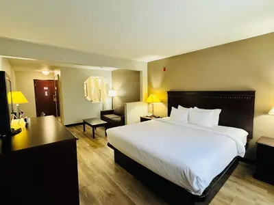 a hotel room with a large bed and a desk at Econo Lodge Inn & Suites Monroe in Monroe