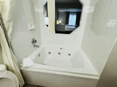 a white bath tub in a bathroom with a mirror at Econo Lodge Inn & Suites Monroe in Monroe
