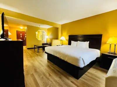 a hotel room with a large bed and yellow walls at Econo Lodge Inn & Suites Monroe in Monroe