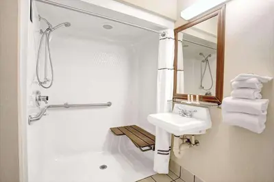 a white bathroom with a sink and a shower at Baymont by Wyndham Monroe in Monroe