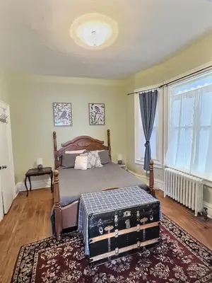 a bedroom with a bed and a large window at Historic LaSalle Downtown in Fort Wayne