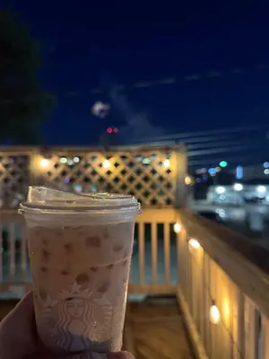 a hand holding a cup of coffee on a balcony at Historic LaSalle Downtown in Fort Wayne