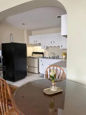 a kitchen with a table and a black refrigerator at Historic LaSalle Downtown in Fort Wayne