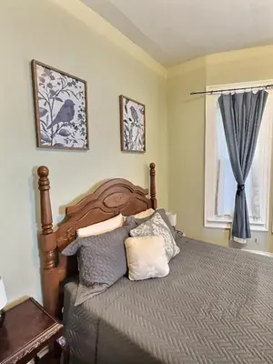 a bedroom with a bed with pillows and a window at Historic LaSalle Downtown in Fort Wayne