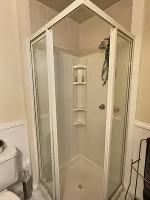 a shower with a glass door in a bathroom at Historic LaSalle Downtown in Fort Wayne