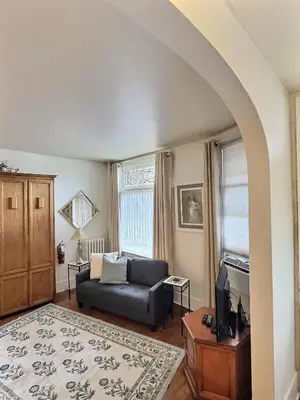 a living room with a couch and a tv at Historic LaSalle Downtown in Fort Wayne