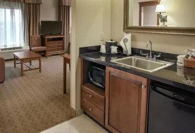 a hotel room with a sink and a living room at Hampton Inn & Suites Youngstown-Canfield in Canfield