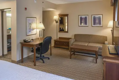 a hotel room with a desk and a bed and a couch at Hampton Inn & Suites Youngstown-Canfield in Canfield