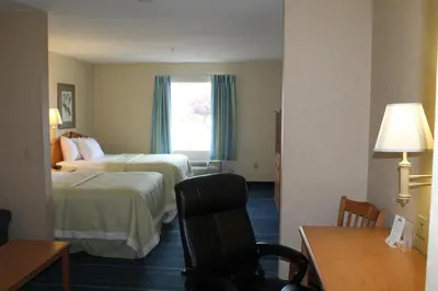 a hotel room with two beds and a window at Days Inn & Suites by Wyndham Bridgeport - Clarksburg in Bridgeport