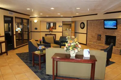 a lobby with a waiting room with a fireplace at Days Inn & Suites by Wyndham Bridgeport - Clarksburg in Bridgeport