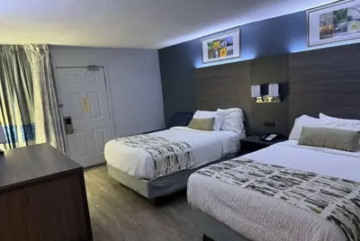 a hotel room with two beds and a door at Baymont by Wyndham Dayton North in Dayton