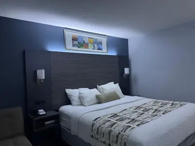 a bedroom with a large bed with a blue wall at Baymont by Wyndham Dayton North in Dayton