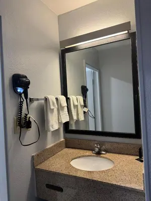 a bathroom with a sink with a mirror and a phone at Baymont by Wyndham Dayton North in Dayton