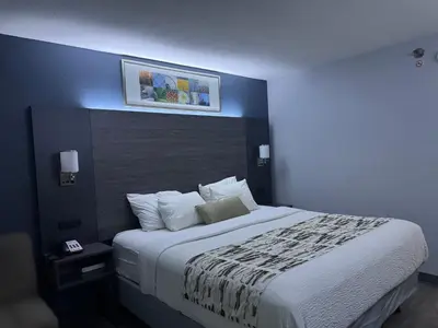 a bedroom with a large bed with a blue wall at Baymont by Wyndham Dayton North in Dayton