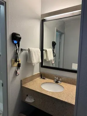 a bathroom with a sink and a mirror at Baymont by Wyndham Dayton North in Dayton