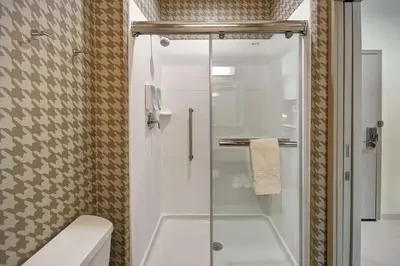 a bathroom with a shower with a toilet and a sink at Home2 Suites By Hilton Columbus Downtown in Columbus