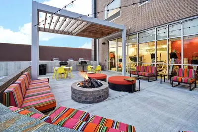a patio with a fire pit and chairs and tables at Home2 Suites By Hilton Columbus Downtown in Columbus