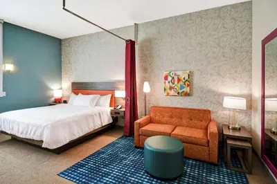a hotel room with a bed and a chair at Home2 Suites By Hilton Columbus Downtown in Columbus