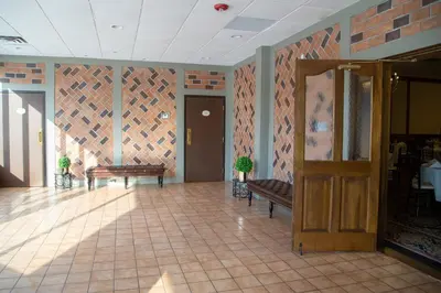 a lobby with two benches and a wooden door at The Stables Inn & Suites in Salem