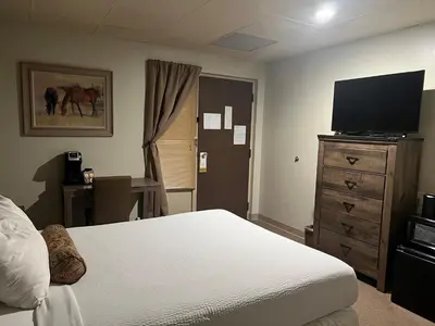 a bedroom with a bed and a flat screen tv at The Stables Inn & Suites in Salem