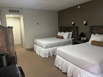 a hotel room with two beds and a television at The Stables Inn & Suites in Salem