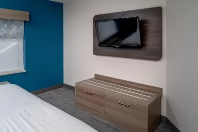 a bedroom with a bed and a tv on a wall at Holiday Inn Express - Charleston/Kanawha City by IHG in Charleston