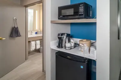a small kitchen with a microwave and a refrigerator at Holiday Inn Express - Charleston/Kanawha City by IHG in Charleston